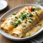 Creamy Chicken Enchiladas topped with melted cheese and sauce