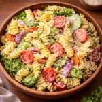 A vibrant bowl of Delicious Ranch Pasta Salad on a sunny wooden table