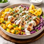 Jerk Chicken and Mango Slaw Bowls with Honey Lime Cream on a wooden table
