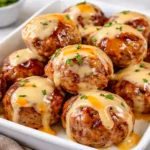 Golden-brown Paula Deen Sausage Balls on a white platter with mustard dip.