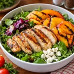 A colorful Grilled Peach and Chicken Salad with goat cheese and balsamic dressing.
