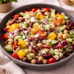 A vibrant bowl of Mediterranean Bean Salad With Feta on a sunlit kitchen counter.