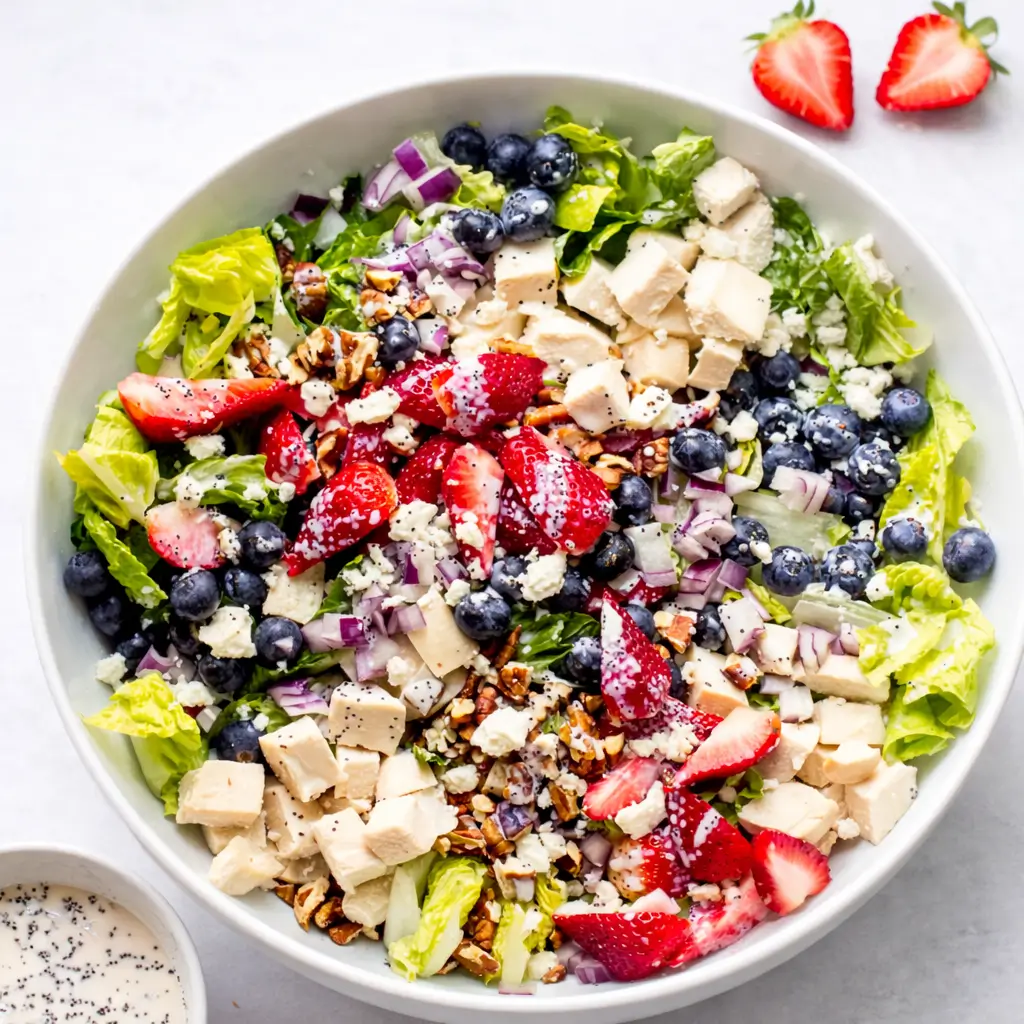Panera Strawberry Salad with fresh berries and chicken in a white bowl