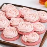 A tray of frosted Pink Lemonade Cookies with lemon slices.