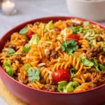 A vibrant bowl of Quick Taco Pasta Salad with Doritos and fresh vegetables.