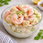 Refreshing Shrimp Pasta Salad in a white bowl on a wooden table.