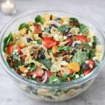 Strawberry Fields Pasta Salad with fresh strawberries and spinach in a white bowl.